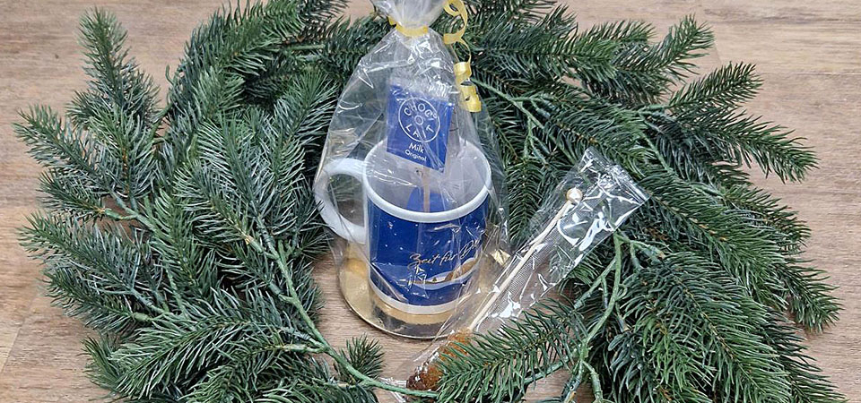 Eingepackte Weihnachtstasse in einem Adventskranz